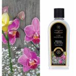 Flasche Ashleigh & Burwood Lamp Fragrance Freesia & Orchid vor Orchideenblüten