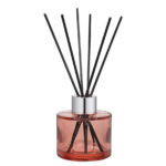Nahaufnahme eines rosa Diffusers mit silbernem Verschluss und Duftstäbchen