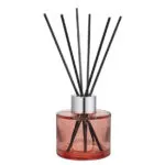 Nahaufnahme eines rosa Diffusers mit silbernem Verschluss und Duftstäbchen