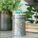 Galvanisierte Duftlampe mit Lochmuster und blauen Wachswürfeln auf einem Tisch