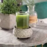 Geometrisch gemusterte Duftlampe mit grünem Glasbehälter auf Tisch
