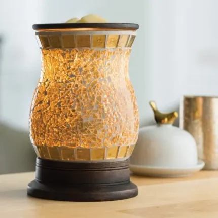 Beleuchtete Duftlampe mit goldfarbenem Glas auf einem Holztisch