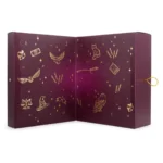 Geöffneter Adventskalender mit nummerierten Türchen und goldenen Zauberwelt-Motiven