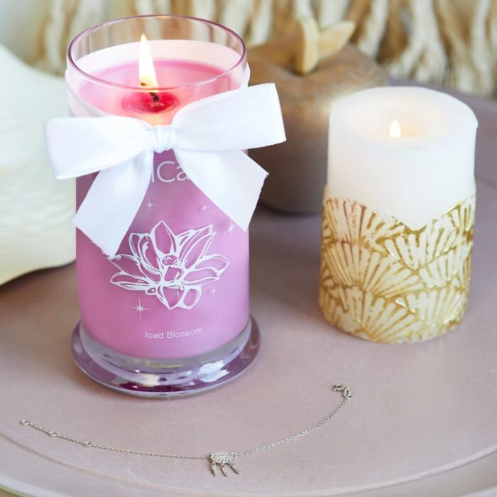 Brennende rosa Iced Blossom Kerze neben weiteren Kerzen