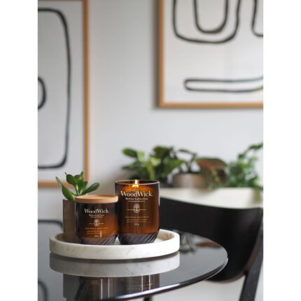 Mehrere WoodWick ReNew Collection Kerzen auf Tischen im Wohnraum