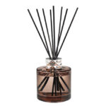 Nahaufnahme eines braunen Diffusers mit schwarzen Duftstäbchen