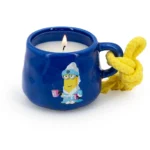 Brennende blaue Kerzentasse mit Kevin-Motiv und gelber Kordel