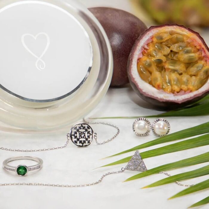 Draufsicht auf Jewel Candle mit Passionsfrucht, Ananasblättern und Schmuckstücken