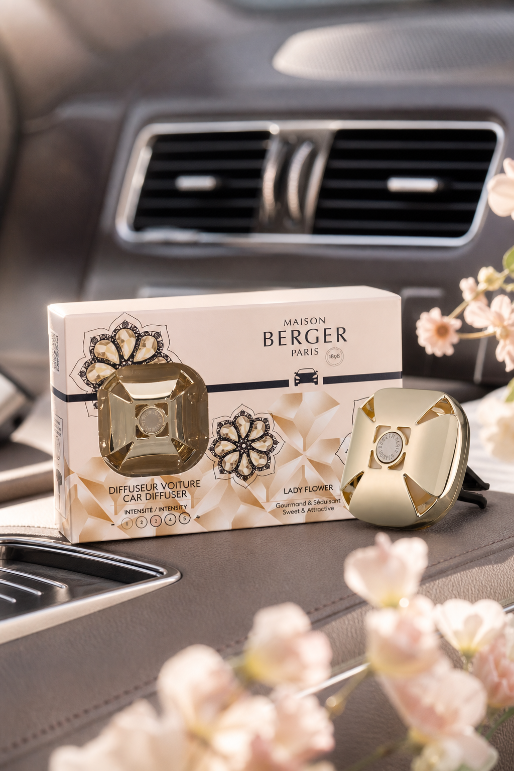 Maison Berger Paris Autoduft-Set liegt vor einer Fahrzeuglüftung auf einem Autositz