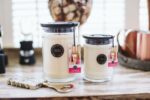 Zwei Bridgewater Kerzen im Glas neben Wohnaccessoires auf einem Holztisch
