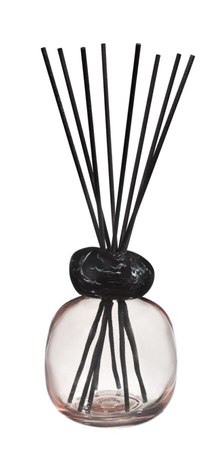 Nahaufnahme des Raumduft-Diffusers mit rundem Glasgefäß und aufgefächerten schwarzen Duftstäbchen