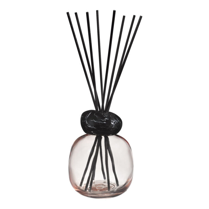 Nahaufnahme des Raumduft-Diffusers mit rundem Glasgefäß und aufgefächerten schwarzen Duftstäbchen