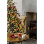 Yankee Candle Kerzen auf Tisch vor Weihnachtsbaum mit brennendem Kamin