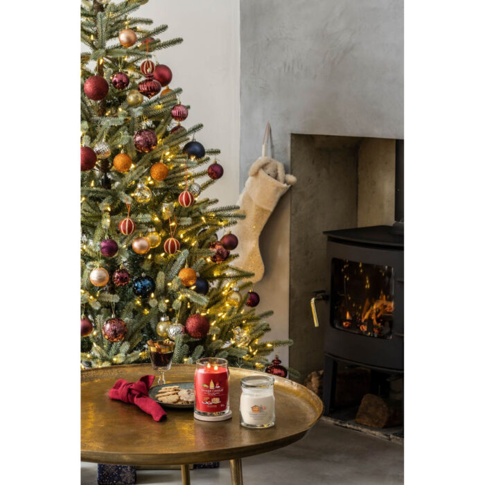 Yankee Candle Kerzen auf Tisch vor Weihnachtsbaum mit brennendem Kamin