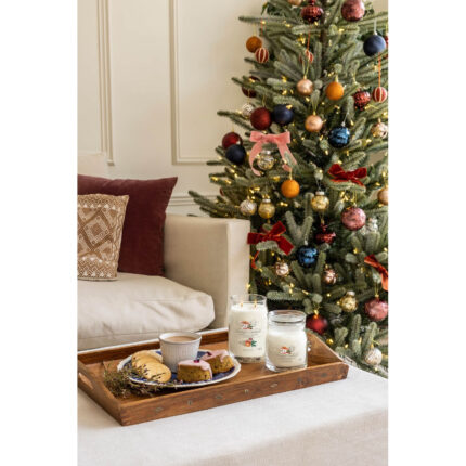 Zwei Yankee Candle Gläser neben Tee und Gebäck vor geschmücktem Weihnachtsbaum