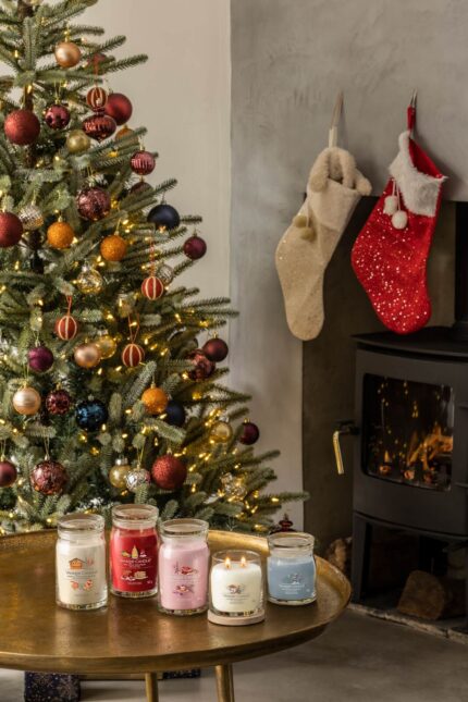 Yankee Candle Kerzen stehen auf einem Tisch neben Weihnachtsbaum und Kamin