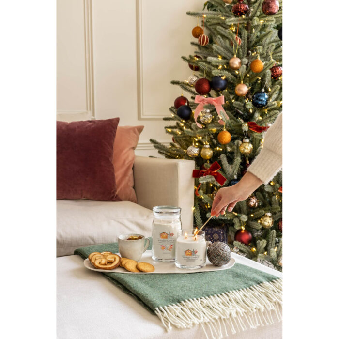 Mehrere Yankee Candle Gläser stehen vor Weihnachtsbaum und Kamin