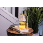 Leuchtender Kerzenwärmer mit Kerze auf einem runden Holztisch