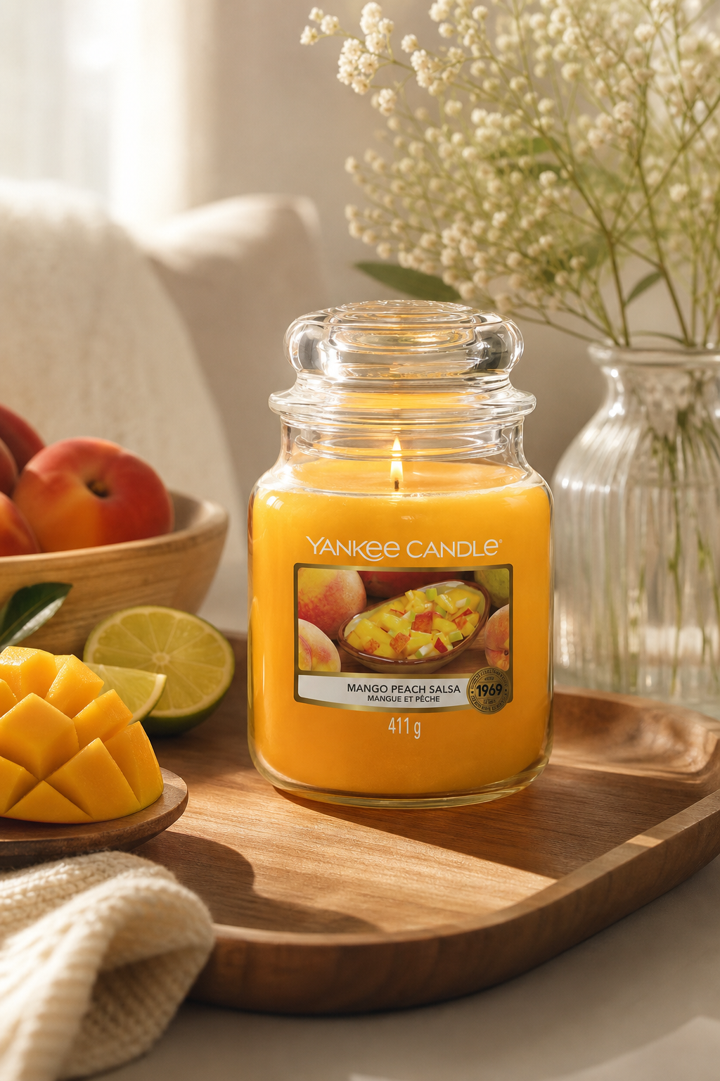 Brennende Yankee Candle Mango Peach Salsa Kerze auf einem Holztablett