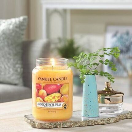 Brennende Yankee Candle Mango Peach Salsa Kerze auf einem dekorierten Tablett