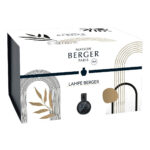 Schwarze marmorierte Lampe Berger auf einem Tisch neben Pflanzen und Buch