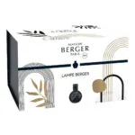 Schwarze marmorierte Lampe Berger auf einem Tisch neben Pflanzen und Buch