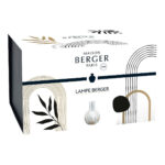 Weiße runde Lampe Berger steht auf einer hellen Tischplatte im Wohnraum