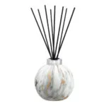 Detailansicht des marmorierten Diffusers mit silbernem Verschluss und schwarzen Stäbchen