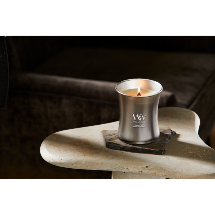 WoodWick Melanite Mist Kerze auf einem mit Moos dekorierten Ast