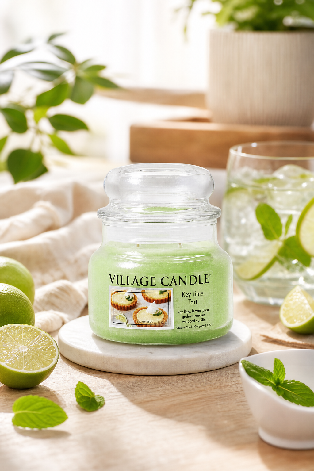 Village Candle Kerze auf Tablett neben Limetten, Minze und einem Getränk