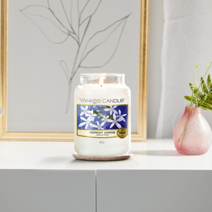Brennende Yankee Candle Midnight Jasmine Kerze auf einem Untersetzer