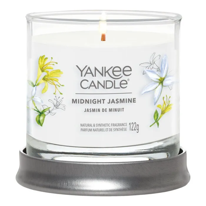 Brennende Midnight Jasmine Kerze im Glas auf grauem Untersetzer