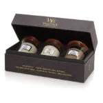 Geöffnetes WoodWick Geschenkset mit drei Mini-Jar-Kerzen auf Tisch