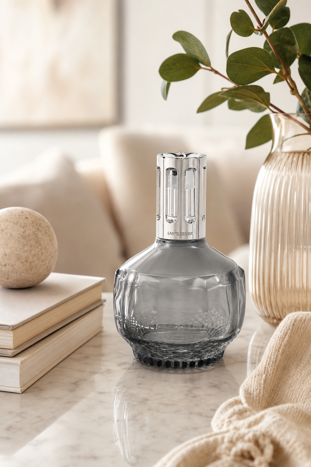 Graue Molecule Lampe Berger steht auf einem Tisch neben Büchern und Vase