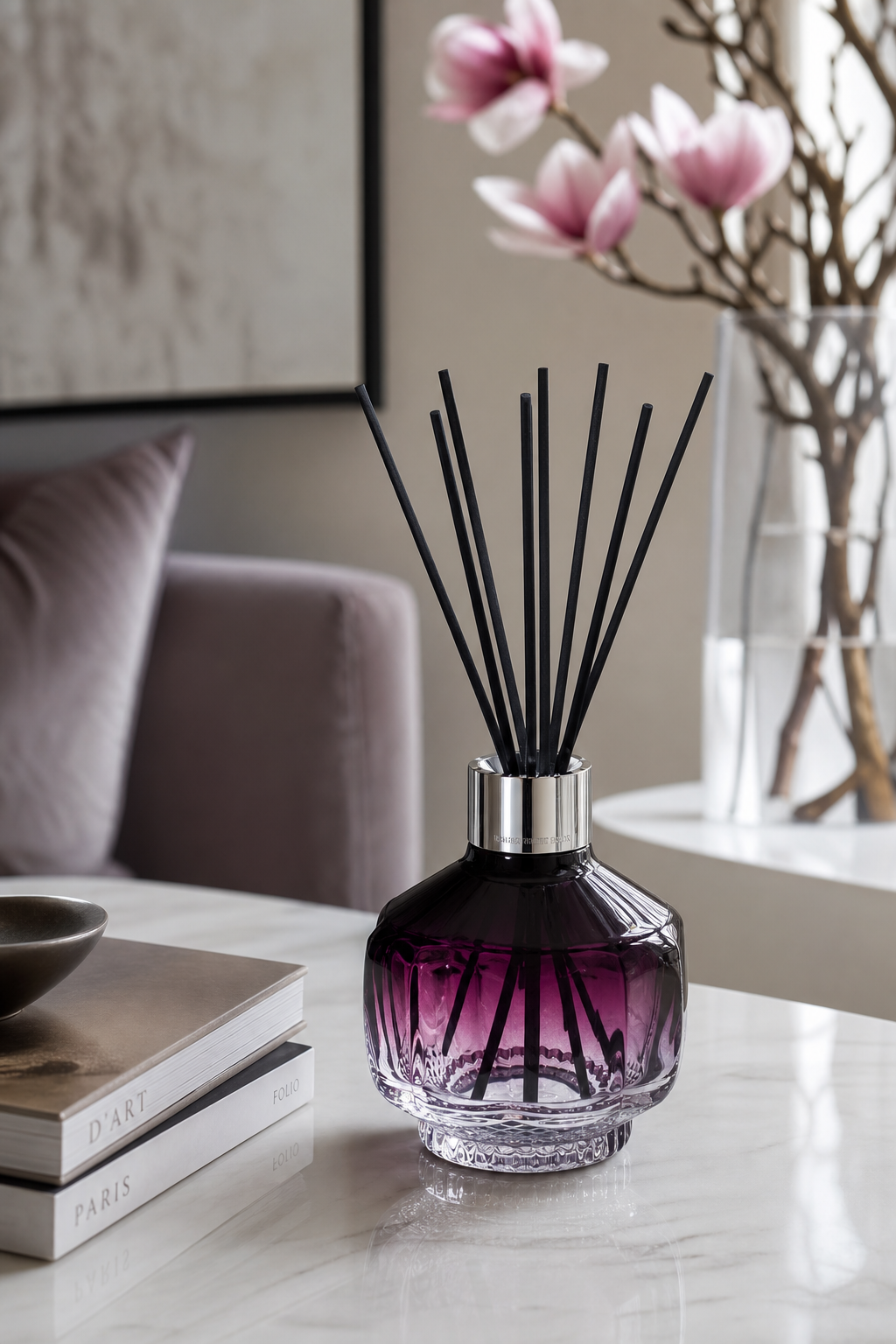 Raumduft-Diffuser mit Duftstäbchen auf einem Tisch neben Magnolienzweigen