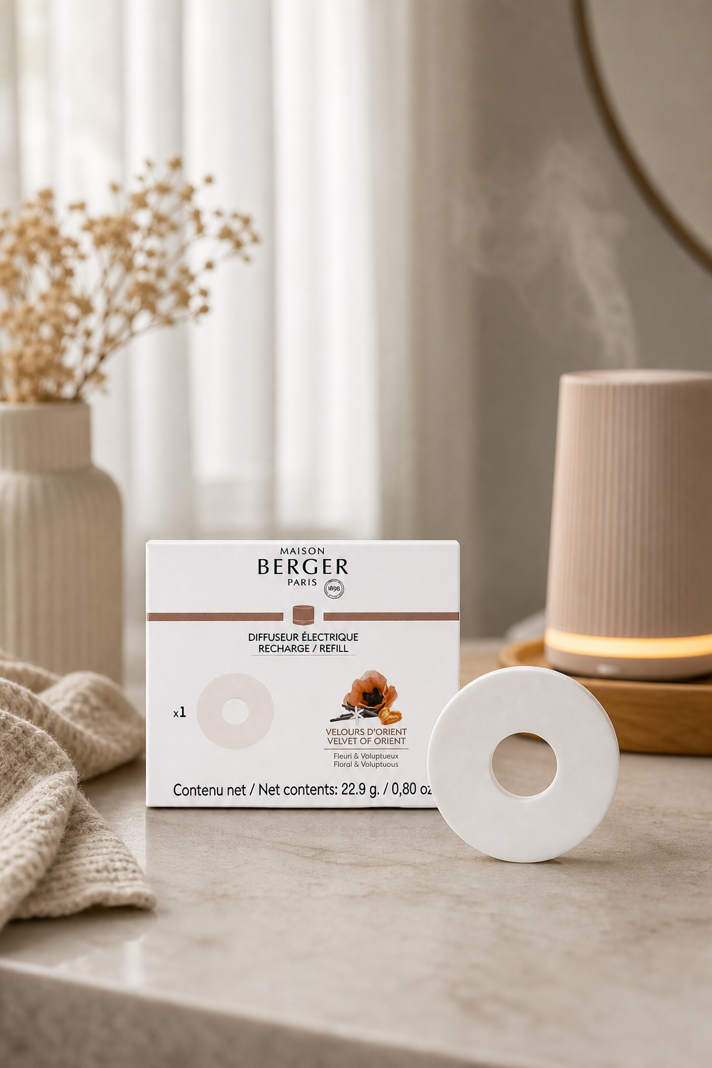 Maison Berger Nachfüller und Verpackung neben eingeschaltetem Diffuser in Wohnumgebung