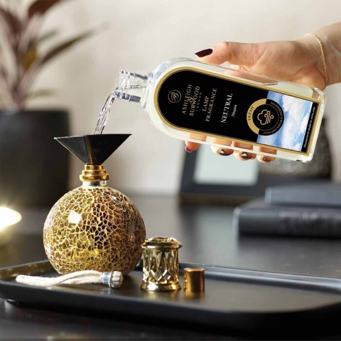 Hand gießt Neutral Lamp Fragrance aus Flasche in eine Duftlampe