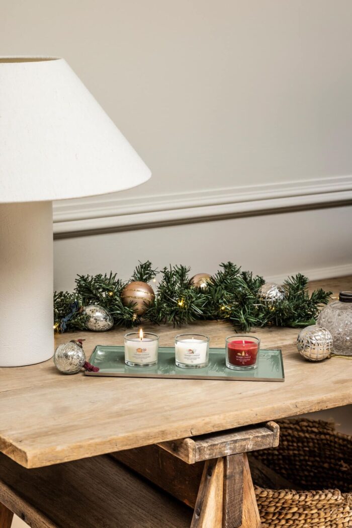 Drei Yankee Candle Kerzen auf einem Tablett mit Weihnachtsgirlande