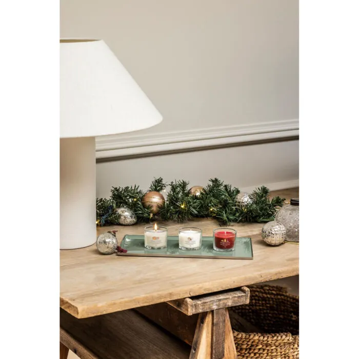 Mehrere Yankee Candle Kerzen stehen vor Weihnachtsbaum und Kamin