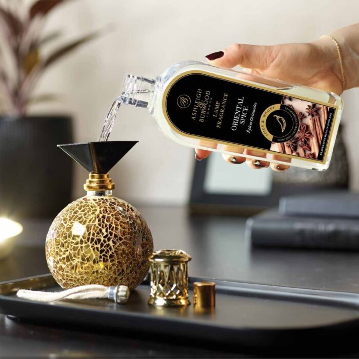Hand gießt Oriental Spice Lamp Fragrance in eine dekorative Duftlampe