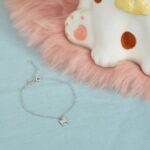 Silberfarbenes Armband mit Hundeanhänger neben der Hundfigur