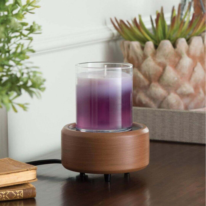 Braune Duftlampe mit violetter Kerze auf einem Tisch