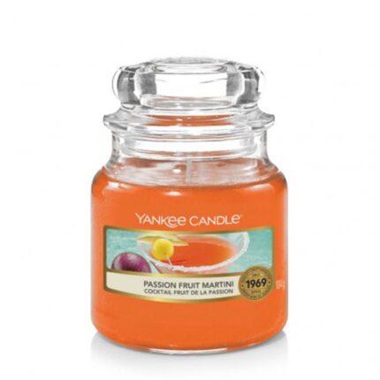 Orangefarbene Duftkerze im Glas mit transparentem Deckel und Passion-Fruit-Martini-Etikett