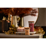 Brennende WoodWick Patchouli Crème Kerze vor Kamin und Sitzbereich