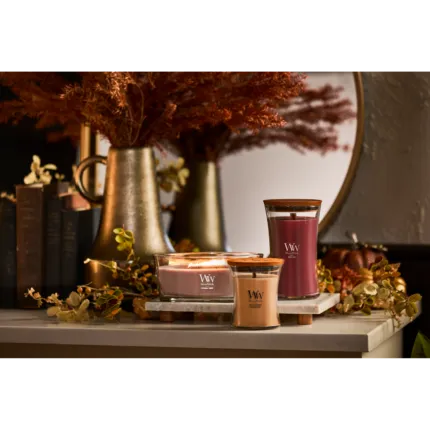 Brennende WoodWick Patchouli Crème Kerze vor Kamin und Sitzbereich