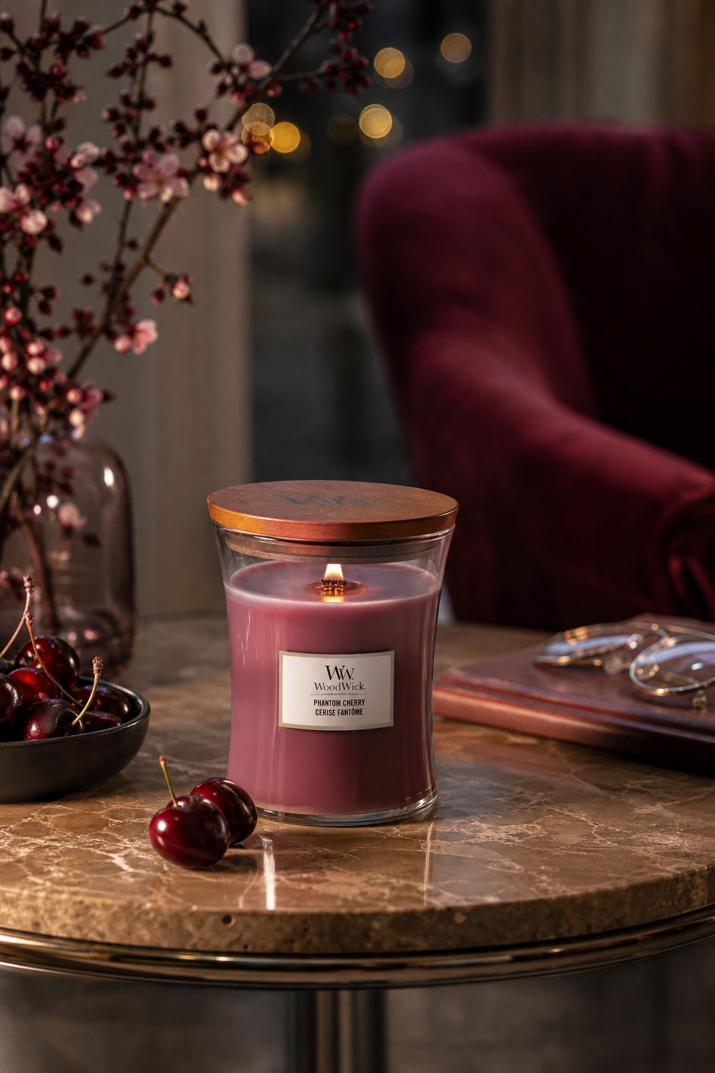 Brennende WoodWick-Kerze Phantom Cherry auf einem Marmortisch