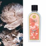 Flasche Pink Peony & Musk Lamp Fragrance neben einer großen Blüte