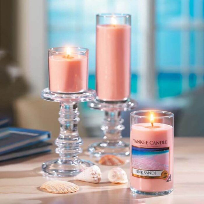 Mehrere brennende rosafarbene Kerzen, darunter eine Yankee Candle Pink Sands Kerze