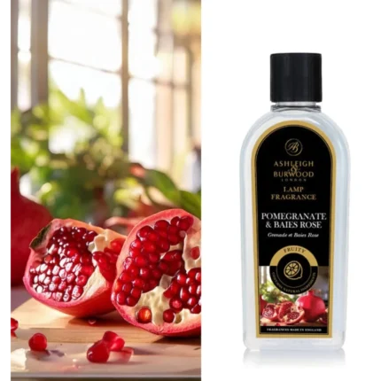 Flasche Lamp Fragrance Pomegranate & Baies Rose neben aufgeschnittenen Granatäpfeln