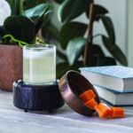 Schwarze Duftlampe mit Glasbehälter und orangefarbenen Wachswürfeln